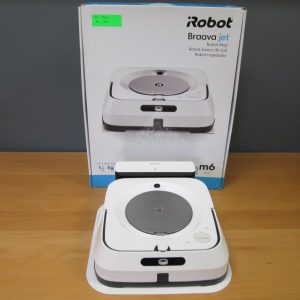 Robot mop on a wooden table in front of its boxed packaging labeled 'iRobot Braava jet' with a green price sticker on the box.